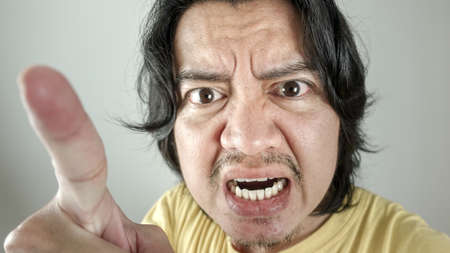 Asian men are angry and pointing on white background.