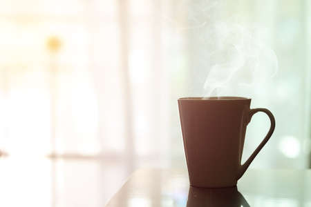 Hot coffee in white cup on a wooden table at morningの写真素材