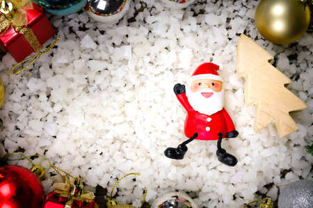 Santa Claus dolls and Christmas decorations on a snow background background with copy spaceの写真素材