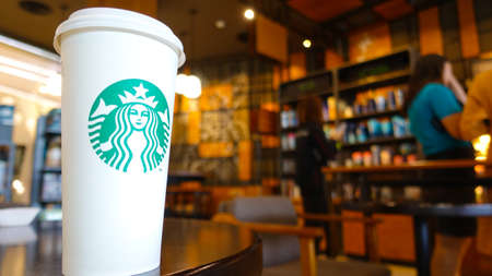 Pathum Thani, Thailand - September 20, 2018 Starbuck hot coffee in a glass of white paper venti size (20oz) on the table to go or drink at the store.のeditorial素材
