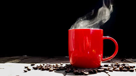 Coffee or tea with hot steam in the morning in red glass on a wooden tableの写真素材