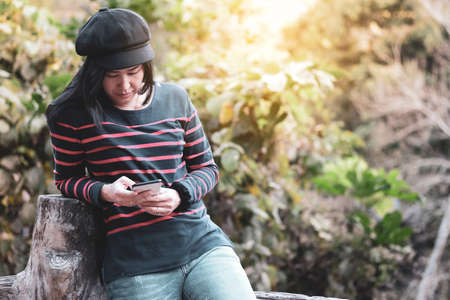 Asian women are holding smart phones and are chatting or doing transactions.の写真素材