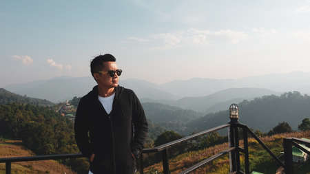 Asian men standing on the terrace at the morning landscape backgroundの写真素材