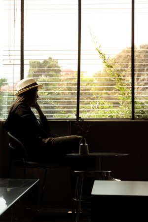 Asian women are sitting waiting for someone and using their thoughts in the dark, lonely and sad emotions.の写真素材