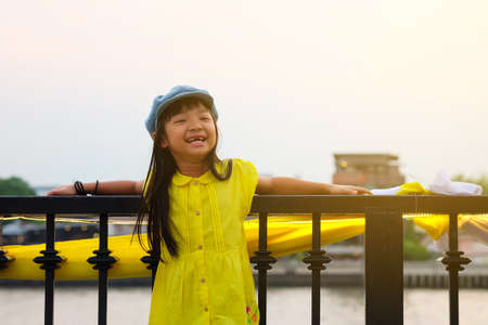 Asian child girls wearing yellow shirts and hats smiling in a good mood On the river atmosphere
