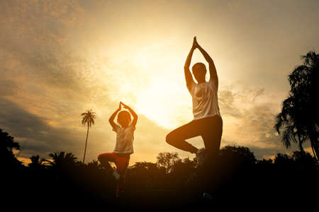The silhouette of the mother and child is exercising in the park.の写真素材