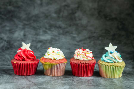 Many sweet colored cupcakes for birthdays, Merry Christmas and New Year 2020 on cement background.の写真素材