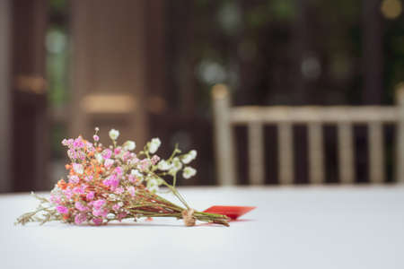 bouquet of multicolored dried flowers placed on the dining table covered with white clothの写真素材