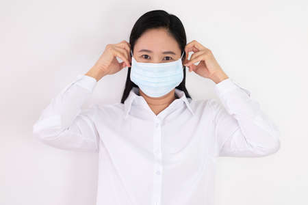 Asian woman in white dress Campaign and demonstrate wearing the right mask on a white backgroundの写真素材