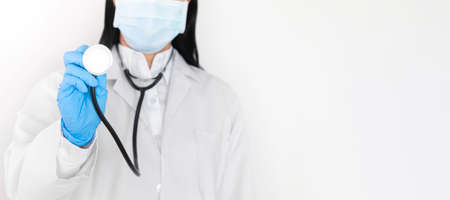 The hand of woman doctor's holding a stethoscope to Check white background with copy space, Covid 19 coping conceptの写真素材