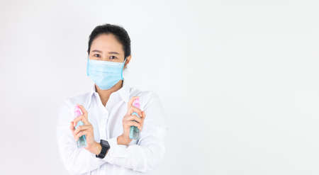 Asian woman are strengthening to overcome the virus by wearing a mask and carrying alcohol bottles for washing hands, cleaning or spraying infected items. Covid-19の写真素材