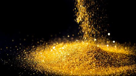 Sprinkle the glittering gold powder on the ground and black background.の写真素材