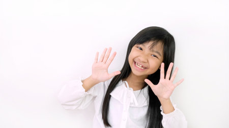 Asian child girls are smiling cute and showing ten fingers on a white background.の写真素材