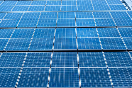 Many solar panels are on the roof of a large facility.の写真素材