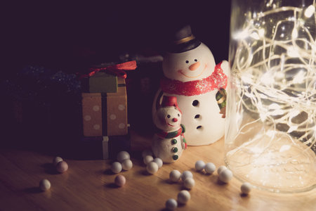Home decoration with lights in glass bottles and snowman dolls, gift boxes and Santa Claus to welcome the season of joy, merry, Christmas and new year 2021.の写真素材