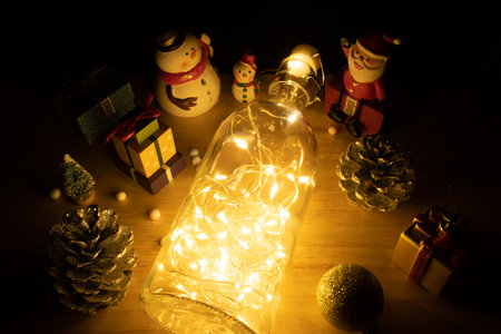 Home decoration with lights in glass bottles and snowman dolls, gift boxes and Santa Claus to...