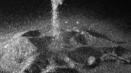 Sparkling silver or platinum glitter powder sprinkled on a black background.の写真素材