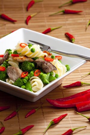 pasta with green vegetables and poultry meatの写真素材