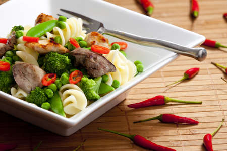 pasta with green vegetables and poultry meatの写真素材