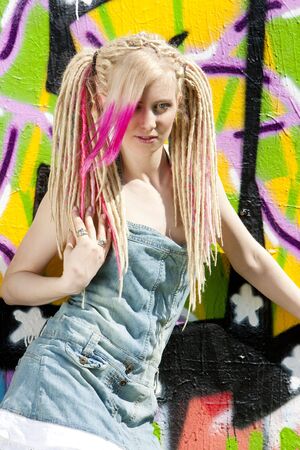young woman standing at graffitti wallの写真素材