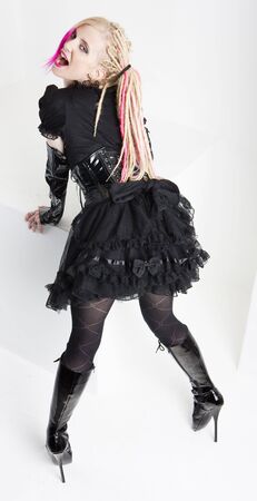 young woman with dreadlocks wearing extravagant clothes and bootsの写真素材