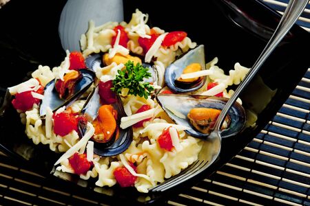 pasta with mussels and chopped tomatoesの写真素材