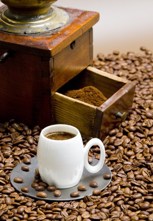 detail of coffee mill with coffee beans and cup of coffeeの写真素材