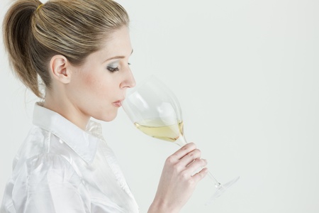 portrait of young woman tasting white wineの写真素材