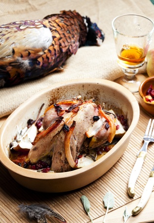 baked pheasant with bacon, pear, raisins on brandyの写真素材