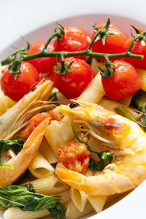 pasta penne with prawns, spinach and grilled cherry tomatoesの写真素材