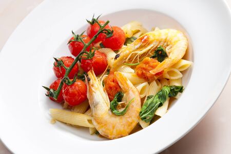 pasta penne with prawns, spinach and grilled cherry tomatoesの写真素材