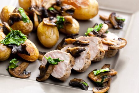 pork tenderloin baked on mushroomsの写真素材