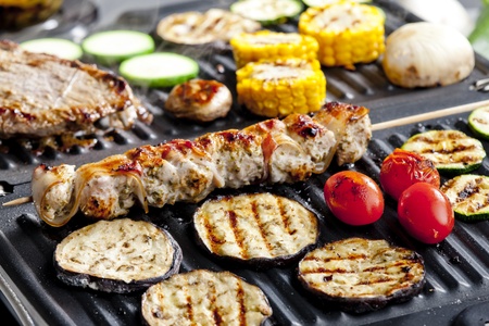 meat skewer and vegetables on electric grillの写真素材