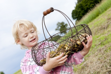 portrait of little girl with basket of mushroomsの写真素材