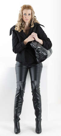 standing woman in black clothes with a handbagの写真素材