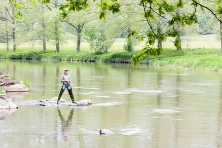woman fishing in Sazava river, Czech Republicの写真素材
