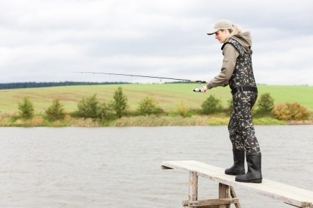 woman fishing on pier at pondの写真素材