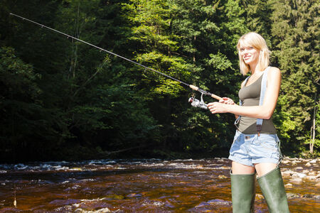 woman fishing in Jizera river, Czech Republicの写真素材