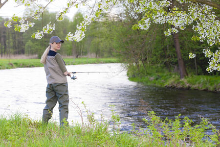woman fishing by the river in springの写真素材