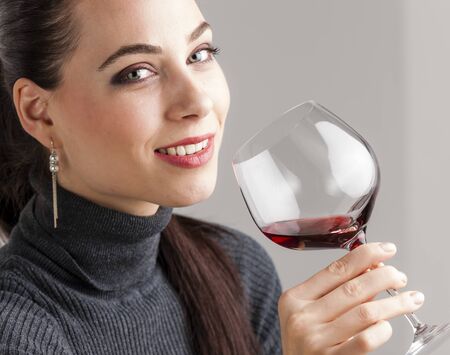 portrait of young woman with a glass of red wineの写真素材