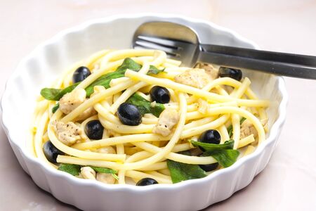 macaroni with chicken meat and black olives on sageの写真素材