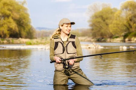 woman fishing in the river in springの写真素材