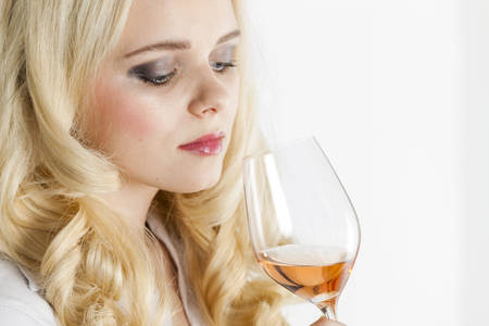 portrait of young woman tasting rose wineの写真素材