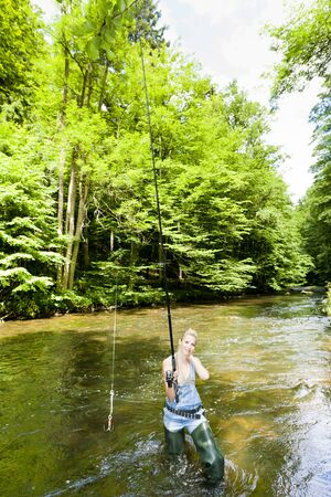 woman fishing in river