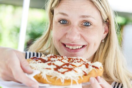 portrait of woman eating langosの写真素材