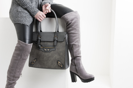 detail woman wearing boots with a handbagの写真素材