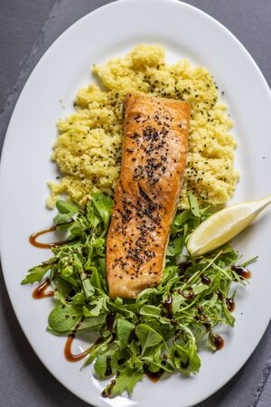 baked salmon with spinach salad and couscousの写真素材