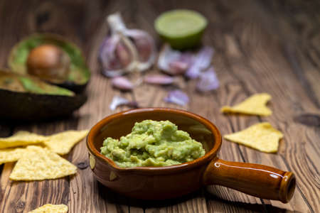 avocado dip flavored with garlic, chili, pepper, and lime juice with corn nachos