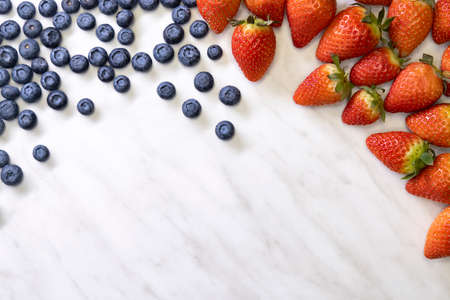 still life with blueberries, strawberries and raspberries on a white patterned backgroundの写真素材