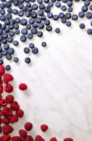 still life with blueberries, strawberries and raspberries on a white patterned background